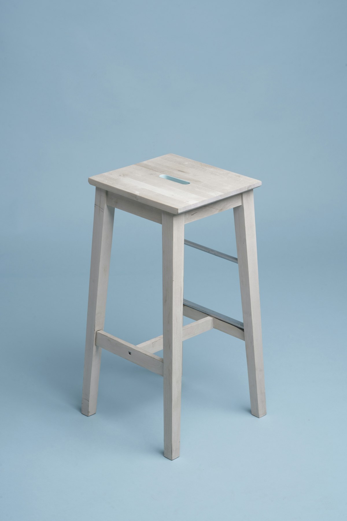 Taburete blanco sobre fondo de estudio azul
